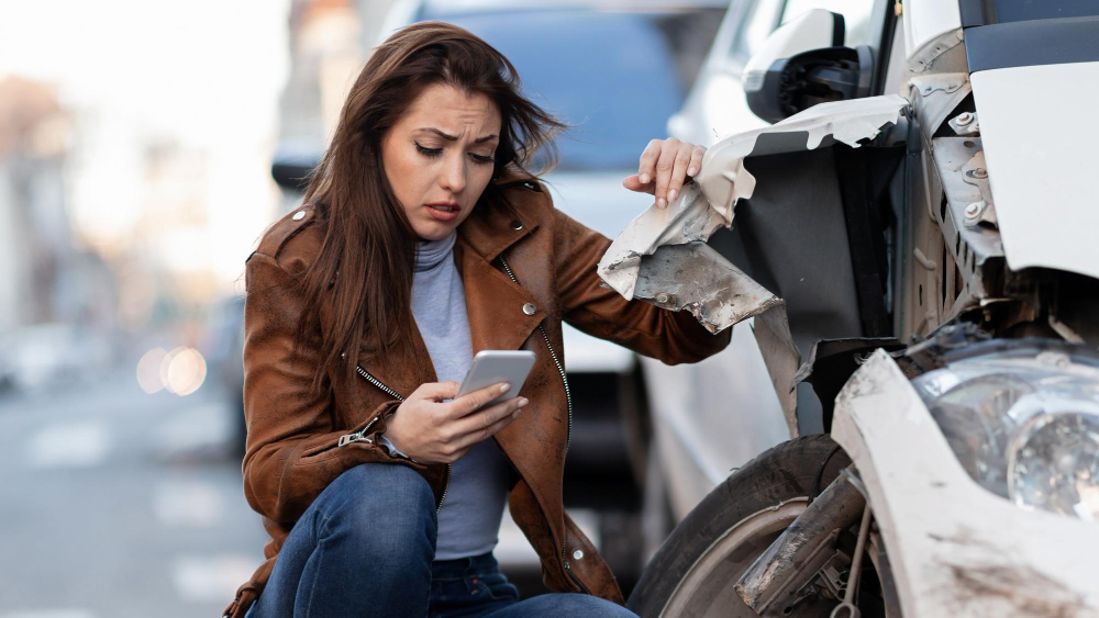 brunette caucasian woman on phone documenting her car accident in Corpus Christi, Texas
