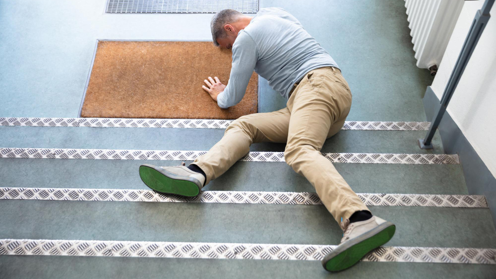 a caucasian man that has fallen down the stairs in a slip and fall injury