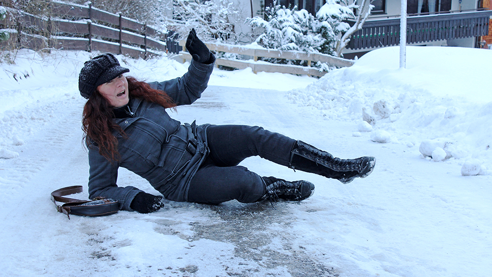 young woman pedestrian on the ground in pain in a slip and fall accident