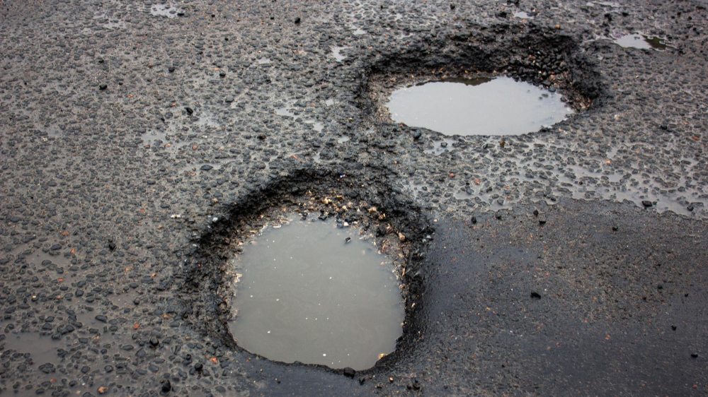 an image of potholes representing poor road maintenance